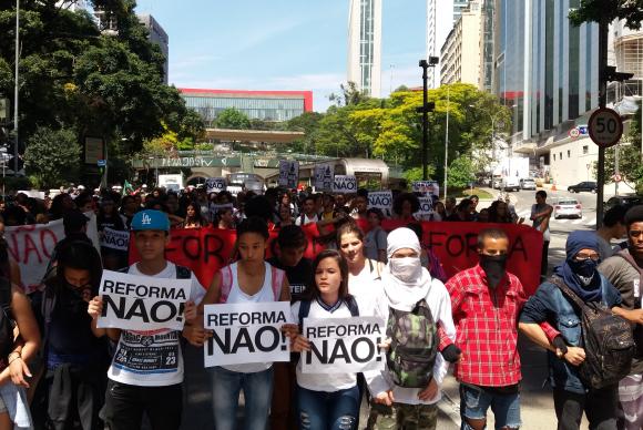 Estudantes em uma rua de São Paulo com faixas e cartazes protestando contra a reforma do Ensino Médio.