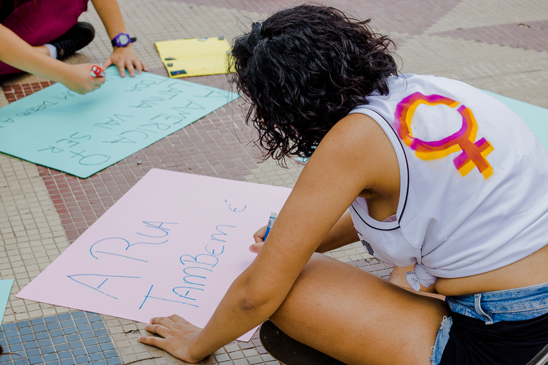 Mulher escrevendo cartaz para a marcha das mulheres