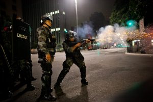 policiais militares atirando contra manifestantes