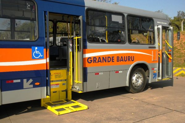 Imagem de um ônibus circular da cidade de Bauru, com as suas portas abertas e sua plataforma adaptada abaixada. Direito à cidade